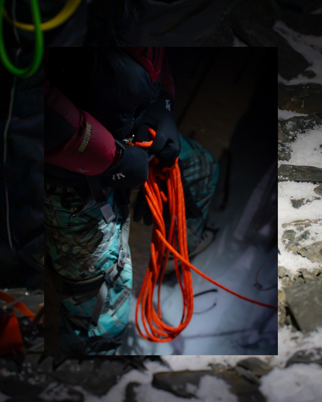 A climber handles orange rope in the dark on Kang Yatse II